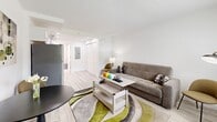 Located along Irlo Bronson Memorial Highway in Kissimmee, Florida, this efficiently designed studio offers a thoughtful layout that maximizes every square foot. The open living area is finished with light wood-look flooring and crisp white walls, creating a bright and airy atmosphere. A window allows natural light to fill the space while offering a view of the greenery outside. The living area accommodates a sleeper sofa, a lift-top coffee table, and a compact dining set, making the space both functional and comfortable.

The kitchen is a standout feature, outfitted with white shaker-style cabinetry, light countertops, and a full suite of stainless steel appliances including a refrigerator, range, and over-the-range microwave. Recessed lighting highlights the clean, modern aesthetic of the kitchen area.

The bathroom is tastefully finished with floor-to-ceiling rectangular white tile surrounding a full soaking tub and shower combination, complemented by marble-look flooring for an elegant touch. A closet with louvered doors provides additional storage within the living area. The overall design is cohesive and contemporary, making this a practical and stylish space in a prime Central Florida location near major attractions.