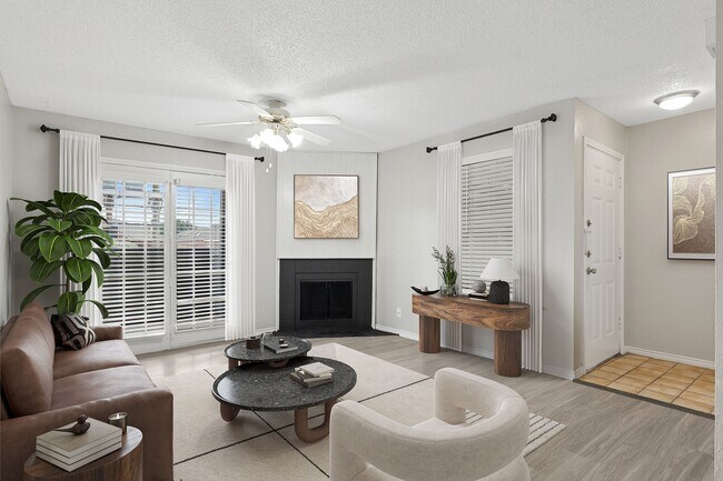 Se muestra una sala de estar renovada con muebles modernos, una acogedora chimenea y vistas a un patio privado. - ReNew Holiday Hill®