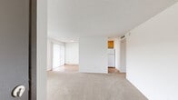 Located at 3514 S 180th St in SeaTac, WA, this one-bedroom, one-bathroom unit offers a practical and well-organized single-floor layout. The open living area features neutral carpet flooring and a textured ceiling, creating a clean, understated aesthetic. Large windows with vertical blinds allow natural light to fill the space and offer views of the surrounding community grounds. A private balcony extends the living area outdoors, providing additional space for relaxation.

The galley-style kitchen is efficiently designed with warm honey-toned wood cabinetry extending from floor to ceiling on both sides, offering generous storage. A double-basin sink with stone-look countertops, a white refrigerator, and a gas range with overhead ventilation complete the kitchen's functional setup. Durable wood-look flooring runs throughout the kitchen, contrasting with the carpeted living and bedroom areas.

The bedroom is a comfortable size, featuring a large sliding window that brings in natural light and outdoor views, along with a dedicated closet. A second closet is conveniently located elsewhere in the unit. The bathroom includes a wood-toned vanity with a stone-look countertop and an integrated mirror, maintaining a cohesive design throughout. This unit offers a straightforward, functional living environment in a residential SeaTac community.