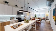 Located at 1 Martine Ave in White Plains, NY, this contemporary single-floor residence offers a thoughtfully designed open-concept layout with high ceilings and warm hardwood flooring throughout. The kitchen is a standout feature, showcasing a two-tone design with sleek white upper cabinetry and natural wood lower cabinets, a textured tile backsplash with under-cabinet lighting, white quartz countertops, stainless steel appliances, and a central island ideal for casual dining. The kitchen flows seamlessly into a dining area and an expansive living room, where large windows invite abundant natural light and offer views of the surrounding White Plains cityscape. The living area features soaring ceilings with exposed track lighting, adding an industrial-modern touch. Two well-appointed bedrooms offer a serene retreat, each with hardwood floors and access to natural light. The two bathrooms are finished with warm wood vanities, white quartz counters, large-format tile flooring, and full tub or walk-in shower configurations. The overall ambiance of this residence is modern and refined, balancing clean architectural lines with warm, natural materials for a comfortable and stylish urban living experience.