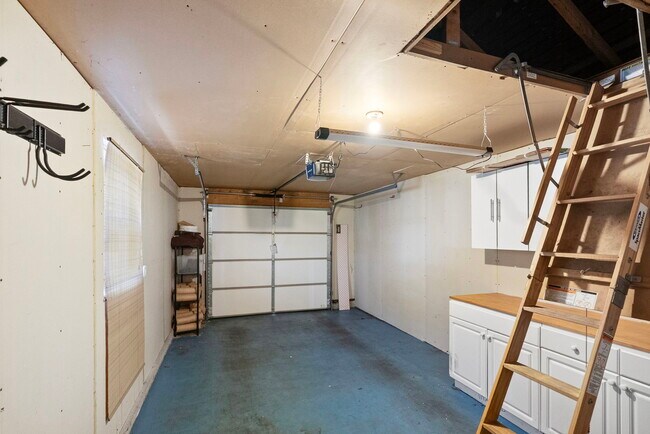 Garaje privado con espacio de almacenamiento incorporado y bancos de trabajo, y un gran ático arriba para más espacio de almacenamiento. - 1220 Weaver Rd NW