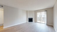 Located at 10225 E Girard Ave in Denver, Colorado, this single-floor residence offers a clean, modern aesthetic defined by a neutral color palette and light wood-style flooring that runs seamlessly throughout. The spacious living area serves as the heart of the home, anchored by a classic fireplace with a white surround and accented by a large sliding glass door that opens to a private balcony, filling the room with natural light and providing outdoor views. A textured ceiling adds a traditional touch to the open, airy atmosphere. The galley-style kitchen is well-appointed with warm wood cabinetry, marble-style countertops, and a full suite of stainless steel appliances, including a range, microwave, refrigerator, and dishwasher, all arranged for functional efficiency. The bedroom offers a generous, open layout with a window that brings in natural light, and connects to a well-designed bathroom featuring a wood-tone vanity, marble-style countertop, undermount sink, and a tiled shower-tub combination. Throughout the residence, clean white trim and soft neutral walls create a bright, cohesive environment that is move-in ready and thoughtfully updated.