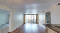 Located at 201 S Fourth St in the heart of San Jose, California, this well-appointed single-floor residence offers a thoughtfully designed layout with a range of modern finishes throughout. The open living area is bright and welcoming, featuring hardwood-style flooring, neutral wall tones, and a textured ceiling. Large sliding glass doors lead directly to a private balcony, allowing abundant natural light to fill the space and providing views of the surrounding cityscape.

The galley-style kitchen is efficiently designed with dark espresso cabinetry, granite-look countertops, a double basin sink, and a full suite of stainless steel appliances including a refrigerator, range, and microwave. A breakfast bar connects the kitchen to the living area, enhancing the open feel.

The bedrooms are generously proportioned, featuring plush carpet flooring and built-in closets with mirrored sliding doors that maximize both storage and the sense of space. One bedroom includes a walk-in closet with built-in shelving.

Both bathrooms are finished with rich dark wood vanities, granite-style countertops, large mirrors, and hardwood-style flooring. Each bathroom includes a shower-tub combination, offering both comfort and practicality. The overall ambiance of the unit is clean, modern, and move-in ready.