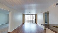 Located at 201 S Fourth St in the heart of San Jose, California, this well-appointed single-floor residence offers a thoughtfully designed layout with a range of modern finishes throughout. The open living area is bright and welcoming, featuring hardwood-style flooring, neutral wall tones, and a textured ceiling. Large sliding glass doors lead directly to a private balcony, allowing abundant natural light to fill the space and providing views of the surrounding cityscape.

The galley-style kitchen is efficiently designed with dark espresso cabinetry, granite-look countertops, a double basin sink, and a full suite of stainless steel appliances including a refrigerator, range, and microwave. A breakfast bar connects the kitchen to the living area, enhancing the open feel.

The bedrooms are generously proportioned, featuring plush carpet flooring and built-in closets with mirrored sliding doors that maximize both storage and the sense of space. One bedroom includes a walk-in closet with built-in shelving.

Both bathrooms are finished with rich dark wood vanities, granite-style countertops, large mirrors, and hardwood-style flooring. Each bathroom includes a shower-tub combination, offering both comfort and practicality. The overall ambiance of the unit is clean, modern, and move-in ready.