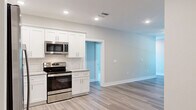 Located at 1147 Midpines Dr in Sanford, NC, this single-story, 3-bedroom, 2-bathroom home offers a clean, modern aesthetic with thoughtfully selected finishes throughout. The kitchen is a standout feature, boasting white shaker-style cabinetry, a subway tile backsplash, granite countertops, stainless steel appliances including a French door refrigerator, gas range, microwave, and dishwasher, all complemented by light wood-look luxury vinyl plank flooring. An adjacent utility area provides added convenience. The two bathrooms are finished with granite-topped vanities and wood-look flooring. The primary bathroom features a walk-in shower, while the second bathroom offers a full tub-shower combo. The three bedrooms are carpeted and finished in neutral tones, with ceiling fans and windows that bring in natural light. The primary bedroom includes access to a dedicated walk-in closet equipped with wire shelving for organized storage. A central hallway connects the rooms efficiently. Throughout the home, white two-panel interior doors, recessed lighting, and a consistent neutral color palette create a cohesive, move-in-ready atmosphere.