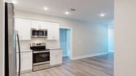 Located at 1147 Midpines Dr in Sanford, NC, this single-story, 3-bedroom, 2-bathroom home offers a clean, modern aesthetic with thoughtfully selected finishes throughout. The kitchen is a standout feature, boasting white shaker-style cabinetry, a subway tile backsplash, granite countertops, stainless steel appliances including a French door refrigerator, gas range, microwave, and dishwasher, all complemented by light wood-look luxury vinyl plank flooring. An adjacent utility area provides added convenience. The two bathrooms are finished with granite-topped vanities and wood-look flooring. The primary bathroom features a walk-in shower, while the second bathroom offers a full tub-shower combo. The three bedrooms are carpeted and finished in neutral tones, with ceiling fans and windows that bring in natural light. The primary bedroom includes access to a dedicated walk-in closet equipped with wire shelving for organized storage. A central hallway connects the rooms efficiently. Throughout the home, white two-panel interior doors, recessed lighting, and a consistent neutral color palette create a cohesive, move-in-ready atmosphere.