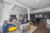 Located at 417 Centinela Ave in Inglewood, California, this thoughtfully designed single-floor space offers a seamless blend of comfort and functionality across a living room and office area. Rich hardwood flooring runs throughout, anchoring the contemporary aesthetic and providing a warm contrast to the crisp white walls and deep navy blue accents found in the office zone.

The living room is bathed in natural light, courtesy of expansive floor-to-ceiling glass walls and sliding doors that open directly to an outdoor courtyard, creating an effortless indoor-outdoor connection. Recessed lighting and structural columns add architectural character, while the open layout encourages a relaxed yet purposeful flow between zones.

The office area features deep navy walls that lend a focused, creative atmosphere. A marble-topped communal table serves as a central gathering point, complemented by a kitchenette with white cabinetry, a stainless steel refrigerator, and a wall-mounted living plant display. A dedicated lounge nook with built-in bench seating, patterned acoustic wall panels, and white-topped tables provides additional workspace or meeting space.

Throughout, curated artwork, open metal shelving, and bold yellow accent pieces add personality and visual interest, making this a dynamic and inviting environment suited for both collaboration and relaxation.