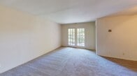 Located at 4202 Conally St in Annandale, Virginia, this single-floor residence offers a practical and comfortable layout designed for everyday living. The expansive living area is carpeted and bathed in natural light, highlighted by elegant French doors that open to an outdoor view of lush greenery, creating a bright and welcoming atmosphere. A hallway connects the living area to the rest of the home, providing a smooth flow between spaces. The kitchen is efficiently designed and features warm oak cabinetry offering generous storage, a gas range, a dishwasher, a double sink, and light-toned countertops, all set over easy-care tile flooring. The bedrooms are carpeted and well-proportioned, each equipped with ceiling fans and windows fitted with slatted blinds for light control. At least one bedroom includes a walk-in closet with built-in shelving, adding valuable storage capacity. The bathrooms are cleanly finished, with one featuring a full tub-shower combination, a wood-toned vanity with an integrated sink, and a mirrored medicine cabinet. The overall aesthetic is neutral and move-in ready, with light-toned walls throughout that lend a clean, airy feel to every room in the home.