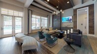 Located at 5500 Home Valley Dr in Raleigh, NC, this single-floor clubhouse is a thoughtfully designed communal space that combines sophisticated style with a wide range of amenities. The lounge area is anchored by exposed dark wood ceiling beams, warm hardwood-style flooring, and large windows that flood the room with natural light and offer outdoor views. Comfortable seating arrangements, a statement chandelier, and a wood-paneled accent wall with a mounted flat-screen TV create an inviting atmosphere for relaxation and socializing. Adjacent to the lounge is a spacious co-working and gathering area featuring soaring ceilings with a striking geometric pendant light fixture, two long white bar-height islands, and additional wall-mounted displays — all framed by floor-to-ceiling windows. A bar kitchenette showcases a bold teal chevron-tile accent wall, floating shelves, dark wood cabinetry, pendant lighting, and a stainless steel sink, providing a functional and visually distinctive refreshment station. The game room rounds out the space with a full billiards table, plush carpet tiles, multiple mounted TVs, pendant lighting, and a stacked stone fireplace with a built-in hearth, delivering a dynamic and entertaining environment throughout.