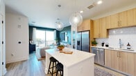 This well-appointed 3-bedroom, 3-bathroom residence at 2490 N Druid Hills Rd in Atlanta, Georgia offers a thoughtfully designed single-floor layout. The open-concept kitchen is a standout feature, showcasing light wood cabinetry, white subway tile backsplash, stainless steel appliances including a refrigerator with ice maker, range, microwave, and dishwasher. A white waterfall-edge island with bar seating and globe pendant lighting anchors the space, flowing seamlessly into the living area. The living room is highlighted by deep teal accent walls, light hardwood flooring, and a large sliding glass door that opens to a private balcony with open views of the surrounding greenery. The primary bedroom offers a serene, light-filled retreat with natural light from multiple windows and light hardwood floors. Additional bedrooms are equally well-lit and comfortable. Each of the three bathrooms is clean and modern, featuring light wood vanities and glass-enclosed walk-in showers with white tile surround. Throughout the residence, light hardwood flooring, recessed lighting, and a neutral color palette contribute to a cohesive, contemporary aesthetic that is both functional and stylish.