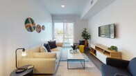 Located at 205–233 E Seaside Way in Long Beach, California, this contemporary single-floor residence offers a thoughtfully designed layout with modern finishes throughout. The kitchen is a standout feature, showcasing dark flat-front cabinetry, a striking black subway tile backsplash, white quartz countertops, stainless steel appliances including a gas range, built-in microwave, dishwasher, and refrigerator, complemented by warm wood open shelving for display and storage. Hardwood-style flooring runs throughout the unit, tying the spaces together seamlessly. The open living area is bright and airy, benefiting from abundant natural light streaming through sliding glass doors that lead to a private balcony with views of the surrounding neighborhood and mature palm trees. The bedroom continues the serene, light-filled atmosphere, featuring direct balcony access framing picturesque palm tree views, along with a spacious closet. The bathroom is clean and modern, with large-format tile surrounding the soaking tub and shower combination, wood-look flooring, and recessed lighting. Overall, the space exudes a calm, contemporary coastal ambiance well-suited to the vibrant Long Beach waterfront neighborhood.