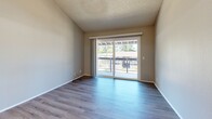 Located at 5109 Andrea Blvd in Sacramento, California, this two-bedroom, two-bathroom residence offers a practical and well-organized single-level layout. Consistent wood-look flooring flows throughout the entire space, complementing the neutral gray and beige tones found in every room.

The combined kitchen and living area serves as the heart of the home. The galley-style kitchen features white cabinetry on both sides, light stone countertops, white appliances including a range and refrigerator, and a single-basin sink — providing ample storage and prep space in an efficient corridor layout. The living room opens directly to a private balcony through a sliding glass door, allowing natural light to fill the space and offering outdoor views of the surrounding area.

Both bedrooms are well-proportioned, featuring textured ceilings, natural light from slatted-blind windows, and sliding closet doors — the primary bedroom with mirrored sliding doors and the secondary with raised-panel white sliding doors. The primary bathroom includes a wide vanity with stone countertop and louvered storage access. The second bathroom features a full soaking tub with tile surround and chrome fixtures. A hallway connects the living spaces to the bedrooms and bathrooms, completing the functional layout of this clean, move-in-ready Sacramento residence.