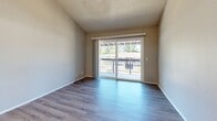 Located at 5109 Andrea Blvd in Sacramento, California, this two-bedroom, two-bathroom residence offers a practical and well-organized single-level layout. Consistent wood-look flooring flows throughout the entire space, complementing the neutral gray and beige tones found in every room.

The combined kitchen and living area serves as the heart of the home. The galley-style kitchen features white cabinetry on both sides, light stone countertops, white appliances including a range and refrigerator, and a single-basin sink — providing ample storage and prep space in an efficient corridor layout. The living room opens directly to a private balcony through a sliding glass door, allowing natural light to fill the space and offering outdoor views of the surrounding area.

Both bedrooms are well-proportioned, featuring textured ceilings, natural light from slatted-blind windows, and sliding closet doors — the primary bedroom with mirrored sliding doors and the secondary with raised-panel white sliding doors. The primary bathroom includes a wide vanity with stone countertop and louvered storage access. The second bathroom features a full soaking tub with tile surround and chrome fixtures. A hallway connects the living spaces to the bedrooms and bathrooms, completing the functional layout of this clean, move-in-ready Sacramento residence.