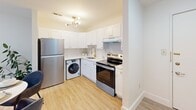 Located at 2101 Reamer Dr in Barrington, NJ, this single-floor, one-bedroom, one-bathroom unit offers a thoughtfully arranged layout that maximizes its compact footprint. The welcoming entrance opens into a spacious living room bathed in natural light through large windows overlooking greenery. Plush carpeting, neutral walls, and a clean, contemporary aesthetic create a calm and inviting atmosphere throughout the living area. Adjacent to the living room, a defined dining area flows seamlessly into the kitchen, which features white shaker cabinets with gold hardware, quartz countertops, stainless steel appliances, and light hardwood-style flooring. A stylish sputnik chandelier adds a modern touch overhead. Notably, an in-unit washer is conveniently integrated into the kitchen space alongside ample cabinetry for storage. The bedroom is a serene retreat, finished with soft carpeting, a window framing outdoor views, and a closet, providing a quiet and comfortable space. The bathroom is clean and functional, featuring a full tub-shower combination with a curtain, wood-look flooring, and brushed nickel grab bar accents. A dedicated utility room rounds out the layout. Throughout, the consistent use of light tones and natural materials creates a cohesive, bright, and move-in ready living environment.