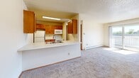 Located at 6010 Creston Ave in Des Moines, Iowa, this two-bedroom, one-bathroom unit offers a practical and comfortable single-floor layout. The open kitchen features warm wood-toned cabinetry, white appliances including a refrigerator, range, dishwasher, and microwave, along with wood-look vinyl flooring and a pass-through counter that connects to the carpeted living area, creating an open and airy feel. Natural light flows into the living space through a large window, complemented by a baseboard heating system. The primary bedroom is a well-sized retreat with a ceiling fan, a window with exterior views, and plush carpeting. It connects to a dedicated walk-in closet outfitted with dual hanging rods and a built-in shelving unit, offering generous storage. The second bedroom also features carpeted floors, a large window, and a sliding door closet. The full bathroom includes a wood-toned vanity, mirrored medicine cabinet, a shower-tub combination, and wood-look vinyl flooring. Textured ceilings are present throughout the unit, adding a consistent design element. Baseboard heaters are found in multiple rooms, ensuring efficient climate control throughout the space.