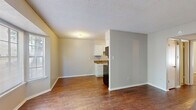 This 550 square foot apartment in Memphis, TN, offers a thoughtful blend of comfort and functionality. The single-bedroom unit, spanning one floor, maximizes space utilization with its well-designed layout. The primary bedroom, at 190 square feet, provides a spacious retreat and includes two closets for ample storage.

The living area features plush carpeting, creating a cozy atmosphere. Large windows allow natural light to flood the space, enhancing the sense of openness. A distinctive bay window adds architectural interest and expands the visual space.

The kitchen, while compact, is efficiently designed with white cabinetry, providing sufficient storage. It features a practical layout with essential appliances and a countertop that doubles as a workspace. The rich, warm-toned hardwood flooring in the kitchen and living area adds a touch of elegance and contrasts beautifully with the lighter wall tones.

The bathroom, though not pictured, completes the essential amenities of this apartment. The overall neutral color palette throughout the space allows for personal customization and creates a bright, airy feel. This apartment offers a balanced living solution, ideal for those seeking a cozy yet functional urban dwelling in Memphis.