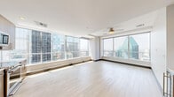 Located in the heart of Dallas, this contemporary high-rise residence offers two bedrooms, four bathrooms, and a thoughtfully designed single-floor layout. Floor-to-ceiling windows in the living area and bedrooms flood the space with natural light while framing dramatic, panoramic views of the downtown Dallas skyline — a defining architectural feature throughout. The open-plan kitchen and living room is anchored by warm wood-tone cabinetry, light hardwood flooring, a full suite of stainless steel appliances, and a built-in wine refrigerator, creating a functional yet refined space for everyday living and entertaining. The generously sized primary bedroom is carpeted for comfort and features expansive city views, while a dedicated walk-in closet with built-in shelving and hanging rods provides ample storage. The primary bathroom is appointed with a dual-sink vanity, wood-grain cabinetry, stone tile flooring, and a gold-framed oversized mirror that adds a refined, upscale touch. Additional bathrooms maintain the same clean, modern aesthetic with neutral tile finishes. A dedicated laundry room with in-unit washer and dryer adds everyday convenience. Two walk-in closets, four full bathrooms, and a neutral color palette complete this well-appointed urban residence.