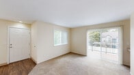 Located in Beaverton, Oregon, this two-bedroom, one-bathroom single-floor home offers a practical and well-organized layout with comfortable living spaces throughout. The living room is bright and inviting, featuring plush carpeting, warm neutral walls, and a sliding glass door that opens to a private balcony with outdoor views — allowing natural light to fill the space. A dedicated dining area sits adjacent to the kitchen, which features a galley-style design with wood-trimmed white cabinetry, a double-basin stainless steel sink, a skylight, and ample counter space. White appliances including a refrigerator and electric range complete the kitchen's functional setup. The primary bedroom offers a comfortable footprint with carpet flooring and a closet, while the second bedroom also features carpet and its own closet. In total, three closets provide generous storage throughout the home. The full bathroom includes wood-look flooring, a vanity with under-sink storage, a wall-mounted mirror, and a tub/shower combination. A dedicated in-unit laundry area with shelving adds everyday convenience. A connecting hallway ties the space together, and wood-look flooring in key areas contrasts neatly with the carpeted living and sleeping zones.