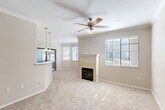 Located at 2100 N 145th Ave in Goodyear, AZ, this single-floor, 2-bedroom, 2-bathroom home offers a well-designed layout with comfortable living spaces throughout. The open-concept living and dining area is a standout feature, highlighted by crown molding, a ceiling fan, soft carpeting, and a tile-surround fireplace that serves as a natural focal point. Large windows fitted with blinds fill the space with natural light, creating a warm and inviting ambiance. An elegant arched doorway connects the living area to the rest of the home, adding an architectural detail that enhances the overall flow.

The kitchen is efficiently arranged with warm wood cabinetry, light countertops, a breakfast bar peninsula with pendant lighting overhead, a double sink, and black appliances including a range and refrigerator. Tile flooring runs throughout the kitchen and bathrooms, while plush carpet covers the living areas and bedrooms.

Both bedrooms are generously sized, each featuring ceiling fans and windows that bring in natural light. The primary bathroom includes a wood-toned vanity, a large mirror, and a tub/shower combination. A second bathroom provides additional convenience. The home also includes five closets for ample storage, a hallway, and a balcony for outdoor enjoyment.