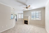 Located at 2100 N 145th Ave in Goodyear, AZ, this single-floor, 2-bedroom, 2-bathroom home offers a well-designed layout with comfortable living spaces throughout. The open-concept living and dining area is a standout feature, highlighted by crown molding, a ceiling fan, soft carpeting, and a tile-surround fireplace that serves as a natural focal point. Large windows fitted with blinds fill the space with natural light, creating a warm and inviting ambiance. An elegant arched doorway connects the living area to the rest of the home, adding an architectural detail that enhances the overall flow.

The kitchen is efficiently arranged with warm wood cabinetry, light countertops, a breakfast bar peninsula with pendant lighting overhead, a double sink, and black appliances including a range and refrigerator. Tile flooring runs throughout the kitchen and bathrooms, while plush carpet covers the living areas and bedrooms.

Both bedrooms are generously sized, each featuring ceiling fans and windows that bring in natural light. The primary bathroom includes a wood-toned vanity, a large mirror, and a tub/shower combination. A second bathroom provides additional convenience. The home also includes five closets for ample storage, a hallway, and a balcony for outdoor enjoyment.