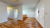 Located at 100 Fieldstone Ln in Monroe, Louisiana, this single-story 2-bedroom, 2-bathroom home offers a practical and comfortable layout throughout. Rich hardwood-style flooring runs consistently across every room, lending warmth and visual continuity to the entire space.

The open-concept living area is bright and inviting, with multiple windows allowing natural light to fill the room. A pendant light fixture hangs above, complementing the airy feel. The kitchen is positioned adjacent to the living area, separated by a wood-paneled breakfast bar with a tiled countertop. The kitchen is well-equipped with warm honey-toned cabinetry, a tile backsplash, white appliances including a refrigerator, electric range, and built-in microwave, plus a skylight overhead that adds extra brightness.

A central hallway connects the main living areas to the bedrooms and bathrooms. The spacious primary bedroom features a ceiling fan, closet, and an en-suite bathroom, providing a private retreat. The second bedroom is similarly sized with a ceiling fan. Both bathrooms are finished with wood-tone vanity cabinetry, tile countertops, and overhead storage. Clean white walls throughout give the home a neutral, move-in-ready aesthetic suitable for personalization.
