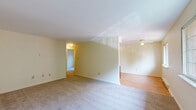 Located at 2568 Western Ave in Altamont, NY, this single-floor, 2-bedroom, 1-bathroom residence offers a straightforward and functional layout designed for comfortable everyday living. The living area is carpeted and bathed in natural light through large multi-pane windows that frame lush, green outdoor views, creating a bright and welcoming atmosphere. Baseboard heating runs throughout, ensuring consistent warmth. The kitchen features rich, warm-toned wood cabinetry, light hardwood-style flooring, a double sink, and white appliances including a refrigerator and dishwasher, providing a practical and organized cooking space. The spacious primary bedroom includes a double-door closet for ample storage and sliding glass doors that open directly to a private outdoor deck, offering serene wooded views. The second bedroom is carpeted and features a ceiling fan, a large window with natural views, and hardwood-style flooring in a portion of the room. The bathroom is fitted with a full tub-shower combination with chrome fixtures and tile flooring. Neutral, cream-toned walls throughout the residence lend a clean and cohesive aesthetic, making this an adaptable space ready for personalization.