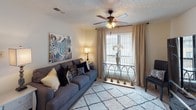 This single-floor, 2-bedroom, 2-bathroom residence delivers a functional and comfortable layout designed for everyday living. The living room serves as the heart of the home, featuring a ceiling fan with light fixture, large window with draping curtains that invite natural light, and soft carpeted flooring throughout. Adjacent to the living area is a dedicated dining space, comfortably sized for a four-seat table, with textured ceilings and tile flooring continuing from the kitchen.

The galley-style kitchen is efficiently arranged with warm wood cabinetry lining both sides, a double-basin sink, white appliances including a refrigerator and dishwasher, and a stainless range. A pass-through window connects the kitchen visually to the dining area, enhancing the sense of openness.

Both bedrooms offer carpeted floors, textured ceilings, and windows that bring in natural light, providing a calm and restful atmosphere. Each bedroom is served by its own full bathroom, both of which feature warm wood vanity cabinetry, tile flooring, a wall mirror with pendant-style lighting, and a shower-tub combination.

Completing the layout is a dedicated in-unit laundry area with washer and dryer hookups and a storage shelf above, adding everyday convenience to this well-appointed residence.