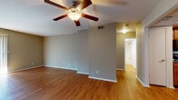 Located at 9320 South College Avenue in Tulsa, Oklahoma, this single-floor residence offers a comfortable and functional layout with consistent design details throughout. The spacious living area is a standout feature, showcasing warm wood-look flooring, a ceiling fan with light fixture, and a fireplace framed by a clean white surround. Large windows and a sliding glass door flood the room with natural light, while vertical blinds provide privacy and light control. The open layout flows seamlessly into adjacent spaces, creating a sense of generous square footage.

The kitchen is well-equipped with rich wood cabinetry, dark countertops, track lighting set within a tray ceiling, and a full suite of black appliances including a gas range, built-in microwave, dishwasher, and refrigerator. A double sink and ample cabinet storage make this a highly functional cooking space.

The residence includes two bathrooms — one featuring a tub and shower combination with a curved curtain rod and warm wood vanity cabinetry, and a second with a sliding glass shower enclosure and matching cabinetry. The bedroom is carpeted for added comfort and includes a ceiling fan and a window for natural light. Wood-look flooring extends throughout the main living areas, tying the space together cohesively.
