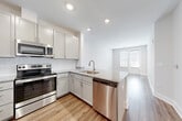 Located at 3378 Aberdeen Row in Chattanooga, TN, this well-appointed single-floor residence combines modern design with practical living. The open-concept layout is unified by warm hardwood-style flooring that extends seamlessly throughout every room, complemented by crisp white walls and clean-lined trim work.

The kitchen is a standout feature, outfitted with a full suite of stainless steel appliances including a refrigerator, electric range, built-in microwave, and dishwasher. Soft gray shaker-style cabinetry with ample upper and lower storage is paired with granite countertops and a classic white subway tile backsplash. A peninsula counter extends toward the living area, enhancing both workspace and flow.

The living and dining areas benefit from natural light streaming through multiple windows fitted with blinds, creating a bright and welcoming atmosphere. The bedroom is generously proportioned, also receiving natural light, and connects directly to a spacious walk-in closet outfitted with wire shelving systems for organized storage.

The bathroom features gray vanity cabinetry with granite counters and includes accessibility-friendly grab bars. A dedicated in-unit laundry closet houses a stacked washer and dryer, adding everyday convenience. The overall design is clean, modern, and move-in ready.