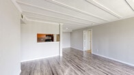 Located at 10225 Bissonnet St in Houston, TX, this 2-bedroom, 3-bathroom single-floor residence offers a practical and well-organized layout. The galley-style kitchen is equipped with warm-toned wood cabinetry, granite-look countertops, a tile backsplash, black appliances including an electric range and refrigerator, and wood-look vinyl flooring that extends into the adjacent living areas. The open sightline from the kitchen into the living space creates a connected, functional flow throughout the home. Both bedrooms feature plush wall-to-wall carpeting, neutral gray walls, and ceiling fans with integrated lighting for year-round comfort. Natural light filters in through windows fitted with blinds, brightening each room. The primary bedroom includes its own dedicated closet space. All three bathrooms are finished with wood-look vinyl flooring, warm-toned wood vanities, granite-look countertops, and full tub/shower combinations with floor-to-ceiling earthy brown tile surrounds. A hallway connects the main living areas to the bedrooms and bathrooms, aided by two additional closets for ample storage. Textured walls and consistent neutral tones throughout give the space a cohesive, move-in ready appearance.