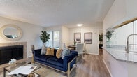 This 1-bedroom, 1-bathroom unit is thoughtfully designed to maximize its footprint across a single floor. The open-concept living area flows seamlessly into a dedicated dining space, creating a comfortable and versatile layout. Wood-style flooring runs throughout, lending a warm and cohesive feel. The living room features a tiled fireplace, a textured ceiling, and a window that brings in natural light, while a second living area provides additional flexibility for lounging or entertaining. The kitchen is equipped with black appliances, including an electric range and over-the-range microwave, complemented by granite-style countertops and a classic white subway tile backsplash. A dedicated closet provides convenient storage access nearby. The bedroom is a comfortable retreat, offering a ceiling fan with light fixture, a window with blinds for natural light, and wood-style flooring. The bathroom includes a full tub-shower combination with white tile surround, a dark-cabineted vanity with granite-style countertop, and wood-look tile flooring. Together, these spaces create a practical and inviting single-story unit with a consistent, modern aesthetic throughout.