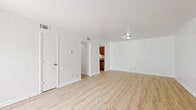 Located at 4600 Twin Oaks Dr in Pensacola, FL, this single-story 2-bedroom, 1-bathroom home offers a clean, modern aesthetic throughout. Light wood-look flooring flows seamlessly across every room, creating a cohesive and bright interior. The open living room provides a welcoming common area with crisp white walls and ample room for furnishings, connecting directly to the kitchen via an open passageway. The kitchen features warm honey-toned wood cabinetry, granite-look countertops, stainless steel appliances including a refrigerator and electric range, and a single-basin sink — a practical and functional layout suited for everyday use. The spacious primary bedroom is filled with natural light courtesy of a large sliding glass door with vertical blinds that opens to an outdoor view of lush greenery. The second bedroom is equally bright and well-proportioned, with clean white walls and access to the hallway. A dedicated closet with built-in wire shelving provides organized storage. The bathroom features a clean white vanity with granite-look countertop, a tub and shower combination, and matching wood-look flooring. A central hallway connects all rooms efficiently, rounding out a practical and comfortable floor plan.