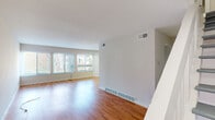 Located at 1169 Jamunda Walk in Saint Louis, MO, this two-story home offers a clean, modern aesthetic with thoughtful updates throughout. The main living area is open and spacious, showcasing warm hardwood floors that reflect abundant natural light streaming in through large windows fitted with horizontal blinds. A staircase connects the two levels, with the doll's-eye view revealing a well-proportioned layout across both floors.

The kitchen stands out with striking navy blue cabinetry, elegant quartz countertops featuring subtle veining, a classic subway tile backsplash, and stainless steel appliances including a gas range and over-the-range microwave. An open pass-through with built-in shelving connects the kitchen area to the adjacent living space.

The bedrooms are bright and airy, each featuring light-toned hardwood floors, ample natural light from double windows, and neutral wall tones that create a calm, welcoming atmosphere. Several rooms include closet access and additional doorways for flexible use.

The bathroom is finished with a navy blue vanity base accented by chrome hardware, a white countertop, and a shower-tub combination. Throughout the home, a consistent neutral palette, updated flooring, and modern fixtures contribute to a cohesive, well-maintained interior.