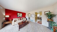 Located at 42 N Lawndale Ave in Indianapolis, Indiana, this two-story, two-bedroom, two-bathroom home offers a well-organized layout spread across two floors. The main level opens into a comfortable living room highlighted by a bold red accent wall, plush carpeting, and large sliding glass doors that lead to an outdoor patio with views of a fenced yard. The galley-style kitchen features warm wood cabinetry, light countertops, a double sink, and standard appliances, opening directly into the living area for easy flow. Adjacent to the kitchen, the dining room accommodates a full-sized table, benefits from natural light through a window with blinds, and connects conveniently to a hallway closet. A full bathroom on the main level is finished with tile flooring and a vanity with cabinet storage. Upstairs, the spacious primary bedroom offers dual closets — including a walk-in — and carpet flooring, providing ample storage. The second bedroom is a well-lit, versatile room with large windows and carpet. A second full bathroom serves the upper level. Throughout the home, neutral tones, carpet flooring, and ceiling fans contribute to a functional and comfortable living environment across both floors.