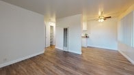 Located at 605 Sorenson Rd in Hayward, California, this single-floor unit offers a clean, functional layout designed for comfortable everyday living. The interior is finished in soft, neutral tones throughout, creating a bright and welcoming atmosphere.

The living area features durable hardwood-style flooring and a large window fitted with vertical blinds that allow natural light to filter through while maintaining privacy. A ceiling fan with integrated lighting adds both comfort and practicality to the space. The open layout connects seamlessly to the kitchen area, which is equipped with white cabinetry and a light-toned countertop, offering a tidy and efficient workspace.

A glass-paneled interior door adds a subtle architectural detail, while a built-in shelving nook provides convenient storage. The bedroom is finished with plush carpeting underfoot and clean white walls, offering a quiet and restful retreat.

The bathroom is well-maintained and features wood-style vinyl flooring, a white vanity with an integrated sink, and a shower-tub combination with a crisp white curtain. A window above the tub allows natural light into the space, and the clean, simple finishes give the room a fresh, functional feel. Overall, the unit presents a practical and move-in ready living environment in a well-established Hayward neighborhood.