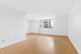 Located on the fourth floor at 1577 Lawrence Avenue West in Toronto, this 2-bedroom, 1-bathroom unit offers a bright and functional layout finished with warm light wood flooring and crisp white walls throughout. The open-concept living and dining area is generously proportioned, seamlessly connected to the kitchen, which is equipped with stainless steel appliances including a full-size refrigerator and stove. Natural light flows into the space through well-placed windows, enhancing the clean, airy atmosphere. The primary bedroom is a comfortable size, featuring a large sliding door closet and easy access to the rest of the unit. Both bedrooms are fitted with sizeable windows that frame views of mature trees and green open space below, lending a calm, natural backdrop. The second bedroom also benefits from ample natural light, making it well-suited as a guest room or home office. The bathroom is finished with full white subway tile surrounding a soaker tub and shower combination, complemented by chrome fixtures for a polished look. The unit's consistent flooring and neutral palette create a cohesive, move-in ready environment throughout.