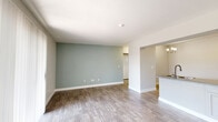 Located at 544 S Camino Seco in Tucson, Arizona, this single-floor, 2-bedroom, 2-bathroom home offers a well-organized layout with a clean, bright aesthetic throughout. The open-concept kitchen and living area serves as the heart of the home, featuring wood-look flooring, a neutral color palette, and a soft sage accent wall that adds a touch of warmth. The kitchen includes white cabinetry, granite-style countertops, and a range, flowing seamlessly into the living space, which is filled with natural light from large windows with vertical blinds. Both bedrooms are carpeted and generously sized, with the primary bedroom offering notable room to accommodate a full furniture arrangement. Each bedroom benefits from natural light and convenient access to the hallways. The two bathrooms are finished with wood-look flooring, white cabinetry, granite-style countertops, and a tub/shower combo with a curved curtain rod and brushed nickel fixtures. Storage is a standout feature, with five closets distributed throughout the home. The hallways are bright and well-lit with wall sconce lighting, and textured walls contribute to the home's character. Overall, the space presents a tidy, functional, and move-in-ready environment suited for comfortable everyday living.