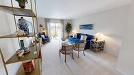 Located at 162 Captains Dr in West Babylon, NY, this well-appointed single-floor home offers a thoughtfully designed layout across one bedroom and one bathroom. The open living and dining area forms the heart of the home, with plush carpeted floors, neutral walls, and a sliding glass door that floods the space with natural light and provides access to an outdoor patio. The living room features a coastal aesthetic with a built-in shelving unit and ample space for relaxing. The adjacent dining area is highlighted by an elegant brass chandelier, a large wall mirror, and a window dressed with sheer curtains that enhance the bright, airy atmosphere. The kitchen is efficiently designed with dark shaker-style cabinetry, white countertops, stainless steel appliances including a range, microwave, and dishwasher, and light hardwood-style flooring. A window above the sink brings in natural light. The generously sized primary bedroom features a serene color palette with a teal accent wall, hardwood flooring, a dedicated vanity area, and windows overlooking the outdoors. The full bathroom is clean and functional, finished with light tile flooring, a white vanity, and a natural light-filled window. A connecting hallway ties all rooms together efficiently.