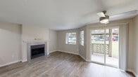 Located at 6455 SW Nyberg Ln in Tualatin, Oregon, this single-floor, one-bedroom, one-bathroom home offers a well-designed layout that makes efficient use of its space. The combined living and dining area serves as the heart of the home, featuring warm wood-look flooring, neutral-toned walls, and a ceiling fan with light. A tile-surround fireplace with a white mantel provides a focal point, while multiple windows fitted with blinds and a sliding glass door flood the space with natural light and offer views of the outdoors. The sliding door opens directly to a private patio, ideal for outdoor relaxation. The kitchen is outfitted with white cabinetry, light countertops, stainless steel appliances including a full-size refrigerator, and an electric range. A dedicated pantry with built-in shelving adds practical storage. The bedroom features plush carpet flooring, a window with natural light, and a baseboard heater. Two closets provide generous storage throughout the unit. The bathroom includes a white vanity with storage cabinets, a large mirror with overhead lighting, and a full tub/shower combo. A dedicated laundry area and entrance complete this thoughtfully arranged home in the heart of Tualatin.