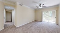Located at 927 Trafford Ln in Savannah, GA, this single-floor, one-bedroom, one-bathroom residence offers a well-organized and efficiently designed layout. The entrance opens into a bright dining area finished with light wood-look flooring, crown molding, and a pendant light fixture, creating a welcoming first impression. The kitchen features white cabinetry, granite-style countertops, stainless steel appliances including a refrigerator, range, and microwave, and a peninsula with a sink that provides a natural division between the kitchen and living areas. The spacious living room is carpeted and accented with crown molding, a ceiling fan, and sliding glass door access that brings in natural light and outdoor views. The bedroom is generously sized, carpeted for comfort, and equipped with a ceiling fan and a window that admits ample natural light. The full bathroom offers a tub/shower combination, a vanity with granite-style countertops, white cabinetry, and bright overhead lighting. A dedicated closet area houses a full-size washer and dryer alongside wire shelving for added storage. Neutral warm-beige tones throughout the space create a cohesive and calm ambiance, making this a functional and comfortable Savannah residence.