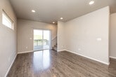 Located at 137 Harvey Dr in Waterloo, Iowa, this three-story home offers 3 bedrooms, 4 bathrooms, and a well-organized layout across three distinct floors. The ground floor features a dedicated living room with gleaming light hardwood flooring, recessed lighting, and windows that invite natural light. The main living level showcases an open-concept kitchen and living area, where dark espresso cabinetry pairs with crisp white quartz countertops and a central island with built-in sink and power outlets. Stainless steel appliances, including a range, microwave, dishwasher, and refrigerator, complete the kitchen. Sliding glass doors lead to an outdoor balcony, extending the living space further. The upper floor houses the bedrooms, each featuring plush carpeting, neutral-toned walls, and windows with outdoor views. The primary bedroom includes a private en-suite bathroom with a walk-in shower. Additional bathrooms are finished with tub-shower combinations, dark vanity cabinetry, white quartz countertops, and stone-look tile flooring. A dedicated laundry room with full-size washer and dryer hookups, multiple closets for storage, and a utility room round out the functional layout of this well-appointed home.