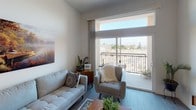 This single-floor residence at 7409 Woodman Ave in Los Angeles offers a thoughtfully designed layout with a clean, contemporary aesthetic throughout. The open-concept living area features wood-style flooring, neutral walls, and a large sliding glass door that leads to a private balcony with open views of the surrounding neighborhood, filling the space with abundant natural light.

The kitchen is efficiently arranged in a galley-style configuration, outfitted with stainless steel appliances including a refrigerator and range, white cabinetry, and dark countertops. Adjacent to the kitchen is a dining area with space for a small table, alongside a hallway that leads to an in-unit stacked washer and dryer — a notable convenience feature.

The bedrooms are well-proportioned, each with windows that bring in natural light and views of the area. One bedroom includes a mirrored sliding closet, while another features a window with vertical blinds. The bathroom is finished in a clean, modern style with a full soaking tub and shower combination, wood-look tile flooring, recessed lighting, and a vanity with a gray countertop. The overall ambiance is bright, functional, and well-suited for everyday living.