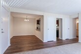 Located along Hidden Glen Drive in Marietta, Georgia, this single-story unit offers a functional and straightforward layout designed for comfortable everyday living. The main living area features a combination of warm hardwood-style flooring and plush carpeting, with large sliding glass doors fitted with vertical blinds that flood the space with natural light and provide direct access to an outdoor area. An adjacent dining space is defined by a simple chandelier overhead, connecting seamlessly to the kitchen through an open doorway.

The galley-style kitchen is equipped with rich, dark wood cabinetry, granite-toned countertops, and black appliances including a range and full-size refrigerator, all set atop hardwood-style flooring. A textured ceiling carries throughout the unit, lending a consistent architectural character to each room.

The bedrooms are carpeted and generously proportioned, with one featuring a double set of bifold closet doors offering ample storage space. Additional bedrooms include standard windows with blinds, providing natural light and privacy. Both bathrooms include tub-shower combinations with tile surrounds, granite-toned vanity countertops, and hardwood-style flooring, maintaining a cohesive design aesthetic throughout the unit.