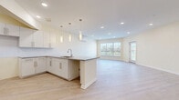 Located at 22 Summit Pl in Branford, CT, this thoughtfully designed single-floor residence offers a bright, modern living experience. The open-concept layout seamlessly connects the kitchen, dining, and living areas into one generous, light-filled space. The kitchen is a standout, featuring crisp white shaker cabinetry with brushed nickel hardware, granite countertops with a peninsula island, a subway tile backsplash, and elegant pendant lighting suspended above. Light hardwood-style flooring runs throughout the main living areas, enhancing the airy, cohesive feel.

The spacious living room benefits from recessed lighting, a wall-mounted mini-split system, and multiple windows and a glass-panel door that invite natural light and outdoor views. A separate den provides additional flexible space, also equipped with a mini-split unit and its own window. The bedroom is generously sized and is complemented by multiple closets, including a large walk-in with wire shelving systems for ample organization.

The bathroom is cleanly finished with tile flooring, a walk-in shower with white subway tile surround, and a modern vanity with dark hardware. A dedicated laundry area and a welcoming entrance complete this well-appointed, move-in-ready home.