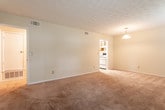 Located in Savannah, GA (31406), this single-floor residence offers a straightforward and functional layout across several well-defined living areas. The open living and dining space is generously sized, featuring plush carpeting, a textured ceiling, and multiple windows that bring in ample natural light with views of surrounding greenery. A pendant light fixture adds a subtle design touch to the dining area.

The galley-style kitchen is efficiently designed, offering rich wood cabinetry on both sides, laminate countertops, a double stainless steel sink, and white appliances including a coil-top range and a full-size refrigerator. The tile flooring in the kitchen provides a clean, durable surface.

The bedroom is a comfortable, carpeted room with a window allowing natural light in and direct access to the bathroom. The bathroom features warm wood vanity cabinetry, a wall-mounted mirror, tile flooring, and a full tub and shower combination with white tile surround and chrome fixtures.

Throughout the residence, neutral cream-toned walls, textured ceilings, and carpeted floors create a cohesive and understated aesthetic. The single-floor layout ensures easy accessibility, and the overall design prioritizes practical living in a convenient Savannah location.