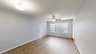 Located at 9988 Windmill Lakes Blvd in Houston, TX, this well-appointed single-story, one-bedroom, two-bathroom home offers a thoughtfully designed layout with a comfortable and functional living environment. The open living and dining areas feature warm wood-look flooring, soft gray walls, and ceiling fans that enhance airflow and ambiance. Large windows with blinds allow natural light to fill the space, creating a bright and inviting atmosphere. The kitchen is equipped with white cabinetry, a gray subway tile backsplash, light countertops, stainless steel appliances including an electric range and over-the-range microwave, and a black refrigerator — all complemented by wood-look flooring and a window overlooking the outdoors. A pass-through connects the kitchen to the adjacent living area. The generously sized primary bedroom features plush carpeting, a ceiling fan, a wide window, and direct access to a bathroom with an extended vanity, dual mirrors, and ample cabinet storage. A dedicated closet and hallway provide additional storage. The home also includes an in-unit laundry area and a private balcony. A second full bathroom and a dedicated hallway round out this efficiently designed and move-in ready home.