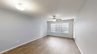 Located at 9988 Windmill Lakes Blvd in Houston, TX, this well-appointed single-story, one-bedroom, two-bathroom home offers a thoughtfully designed layout with a comfortable and functional living environment. The open living and dining areas feature warm wood-look flooring, soft gray walls, and ceiling fans that enhance airflow and ambiance. Large windows with blinds allow natural light to fill the space, creating a bright and inviting atmosphere. The kitchen is equipped with white cabinetry, a gray subway tile backsplash, light countertops, stainless steel appliances including an electric range and over-the-range microwave, and a black refrigerator — all complemented by wood-look flooring and a window overlooking the outdoors. A pass-through connects the kitchen to the adjacent living area. The generously sized primary bedroom features plush carpeting, a ceiling fan, a wide window, and direct access to a bathroom with an extended vanity, dual mirrors, and ample cabinet storage. A dedicated closet and hallway provide additional storage. The home also includes an in-unit laundry area and a private balcony. A second full bathroom and a dedicated hallway round out this efficiently designed and move-in ready home.
