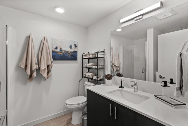 Bright, modern bathroom with sleek finishes and a walk-in shower. - The Ruby