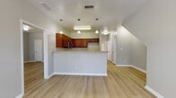 This two-story, 4-bedroom home offers a well-organized layout spread across two levels, finished throughout with light wood-look flooring that lends a clean, cohesive appearance to each room. The main level opens with a welcoming entry featuring a front door with transom window, a ceiling fan overhead, and a staircase leading to the upper floor.

The kitchen is a functional centerpiece, equipped with rich medium-toned wood cabinetry, granite-style countertops, a stainless steel microwave, a dishwasher, and a double basin sink. A peninsula with pendant lighting above provides additional counter space and separates the kitchen from the adjoining living area, creating an open, connected flow between spaces.

The bedrooms feature ceiling fans, natural light from large windows with blinds, and mirrored sliding closet doors that enhance the sense of space. The bathrooms are finished with consistent granite-style vanity tops, wood cabinetry, and tub/shower combinations. One bathroom includes a window for added natural light. Neutral gray walls throughout the home create a calm, versatile backdrop suited to a variety of décor styles.
