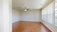 Located at 4525 Secret Garden Dr in Madison, Wisconsin, this multi-level townhome offers a well-organized layout spread across three floors. The ground level features an attached garage with a spacious concrete floor and automatic door opener. The main living floor showcases rich hardwood-style flooring throughout the open-concept living room and kitchen. The living room is bright and airy, enhanced by a ceiling fan, while the kitchen impresses with warm wood cabinetry, dark granite countertops, a breakfast bar peninsula, and a full suite of stainless steel appliances including a refrigerator, range, and built-in microwave. A dedicated laundry room on this level includes overhead cabinetry and a window for natural light. The upper floor hosts two carpeted bedrooms, including a generously sized primary bedroom with a walk-in closet featuring built-in shelving and hanging rods. Bedrooms are bright with large windows offering pleasant neighborhood views. Three bathrooms are distributed throughout, with one featuring a wood vanity, dark granite countertop, tile flooring, and a tiled shower. A private balcony extends from the upper level, offering open views of the surrounding community under wide Wisconsin skies.